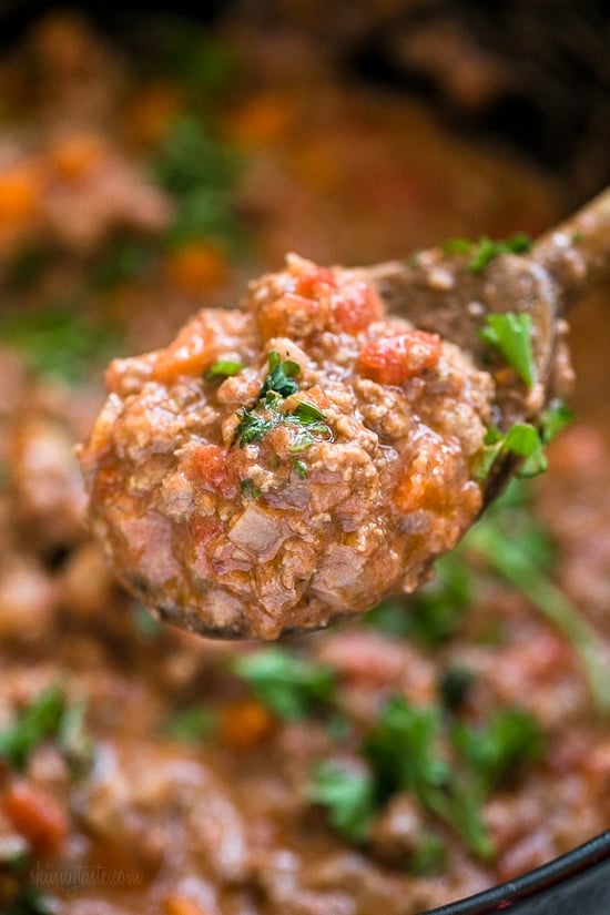 Instant Pot Bolognese sauce is full of flavor and ready in one hour! See how easy it is to make a classic meat sauce in your pressure cooker. Close up of a spoonful of bolognese sauce held over a pot of sauce.