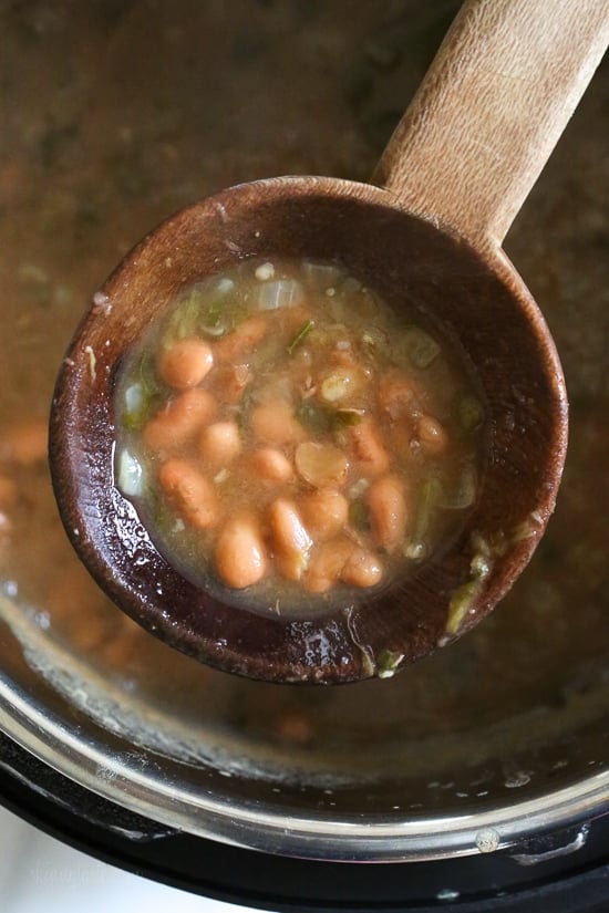 A ladle holding Instant Pot pinto beans.