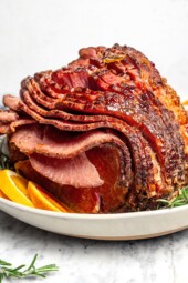 Slow cooker spiral ham on platter with orange slices.