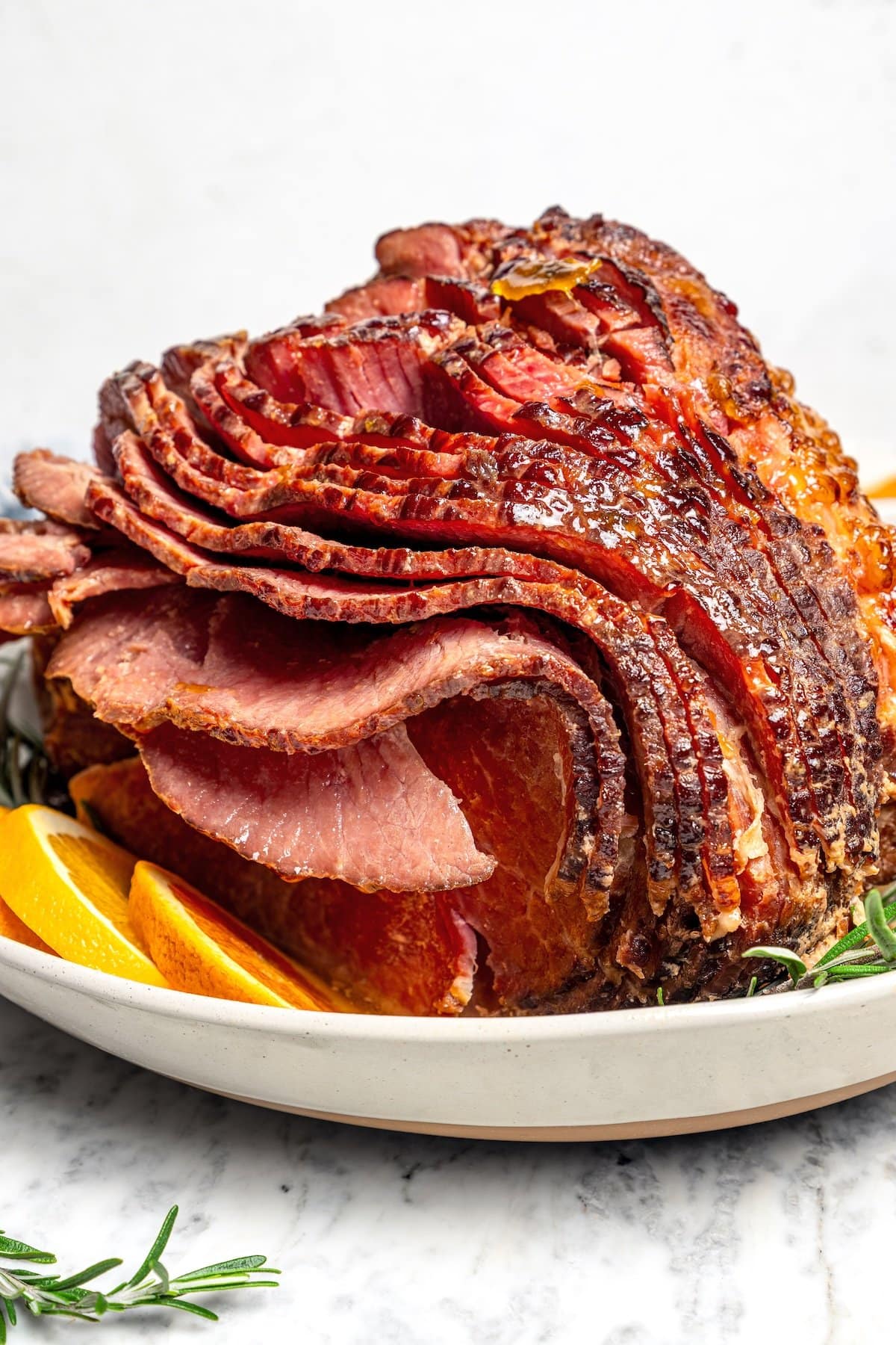 Slow cooker spiral ham on platter with orange slices.