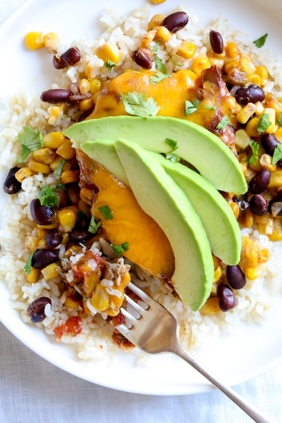 This EASY Slow Cooker Chicken dish is cheesy and delicious, made with boneless chicken breast, black beans, corn and salsa topped with melted cheddar cheese. YUM!