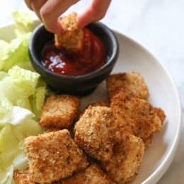 dipping chicken nuggets into ketchup