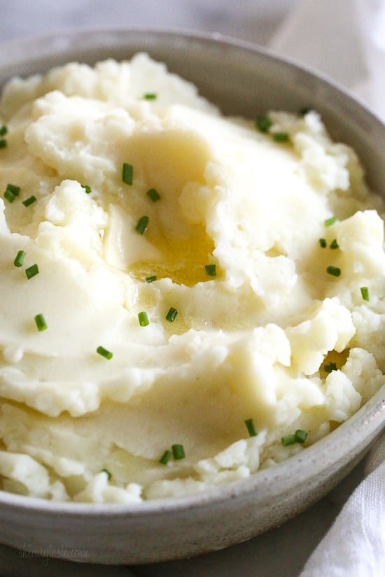 Make creamy Instant Pot mashed potatoes in a fraction of the time! This healthy pressure cooker potatoes recipe is ready in 20 minutes. A bowl of creamy Instant Pot mashed potatoes topped with chopped chives.
