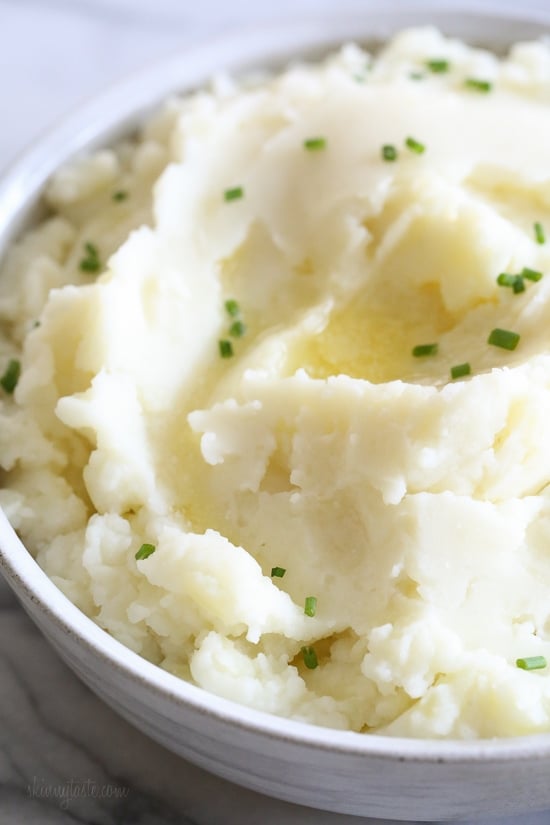 Make creamy Instant Pot mashed potatoes in a fraction of the time! This healthy pressure cooker potatoes recipe is ready in 20 minutes. A bowl of creamy Instant Pot mashed potatoes topped with chopped chives.