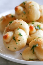 These soft, garlicky knots taste just like your favorite pizzeria’s garlic knots, but made from scratch using my easy yeast-free bagel dough recipe (just flour, Greek yogurt, baking powder and salt).