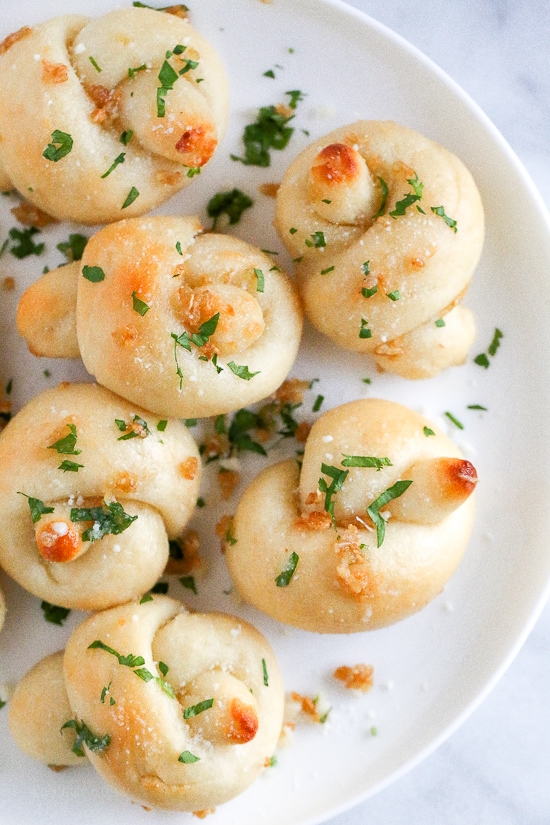 These soft, garlicky knots taste just like your favorite pizzeria’s garlic knots, but made from scratch using my easy yeast-free bagel dough recipe (just flour, Greek yogurt, baking powder and salt).