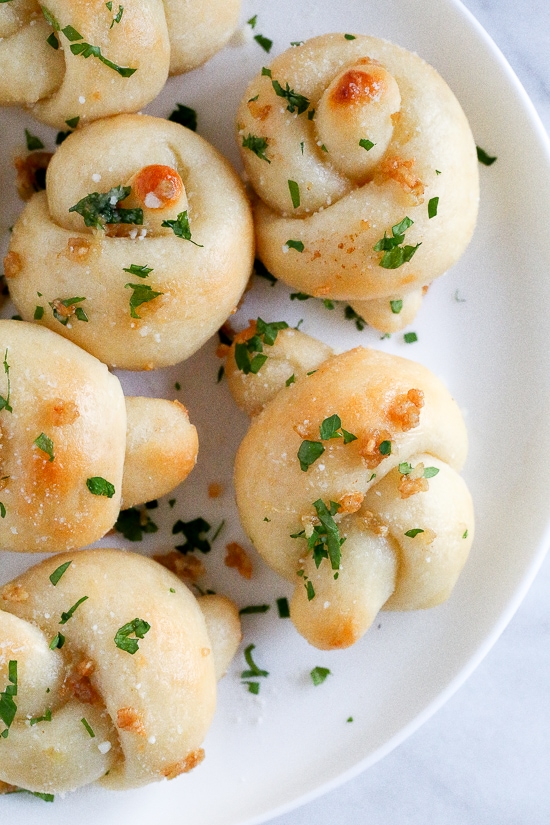 These soft, garlicky knots taste just like your favorite pizzeria’s garlic knots, but made from scratch using my easy yeast-free bagel dough recipe (just flour, Greek yogurt, baking powder and salt).