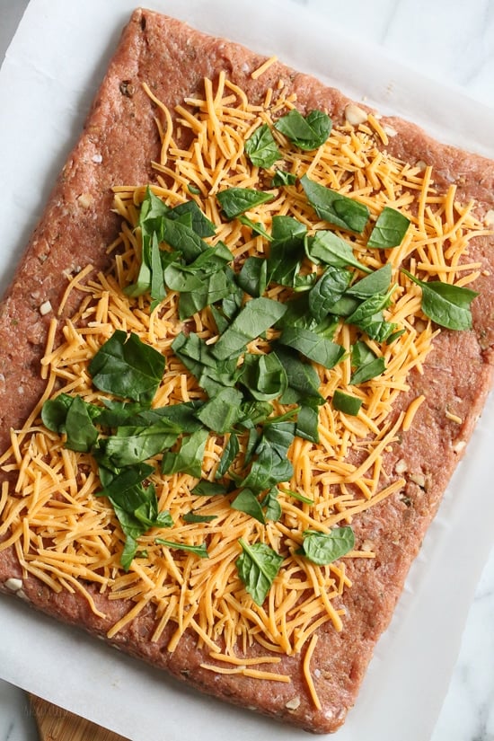 The best tasting, moist turkey meatloaf stuffed with cheddar cheese, spinach and rolled, jelly roll style topped with a ketchup based glaze. 