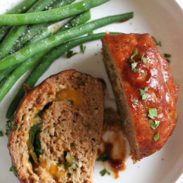 The best tasting, moist turkey meatloaf stuffed with cheddar cheese, spinach and rolled, jelly roll style topped with a ketchup based glaze.