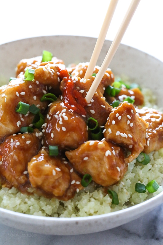 Chopsticks in bowl of General Tso's chicken with cauliflower rice