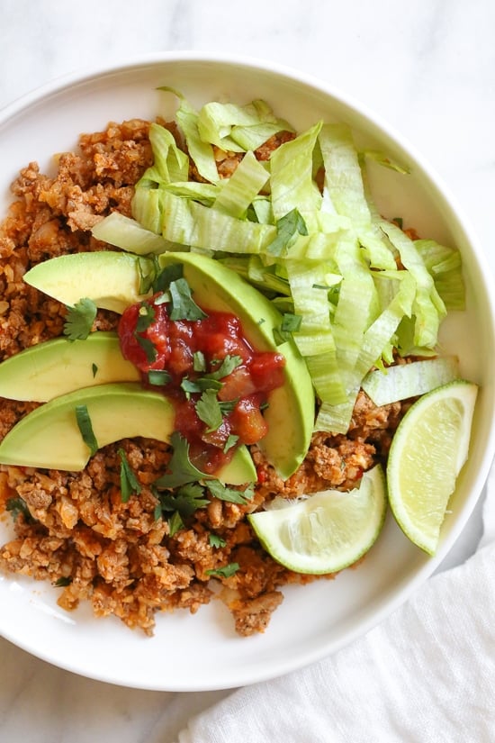 Skillet Taco Cauliflower Rice, an easy skillet dinner made with ground turkey and cauliflower rice topped with lettuce, avocado and salsa for an low-carb, weeknight meal!