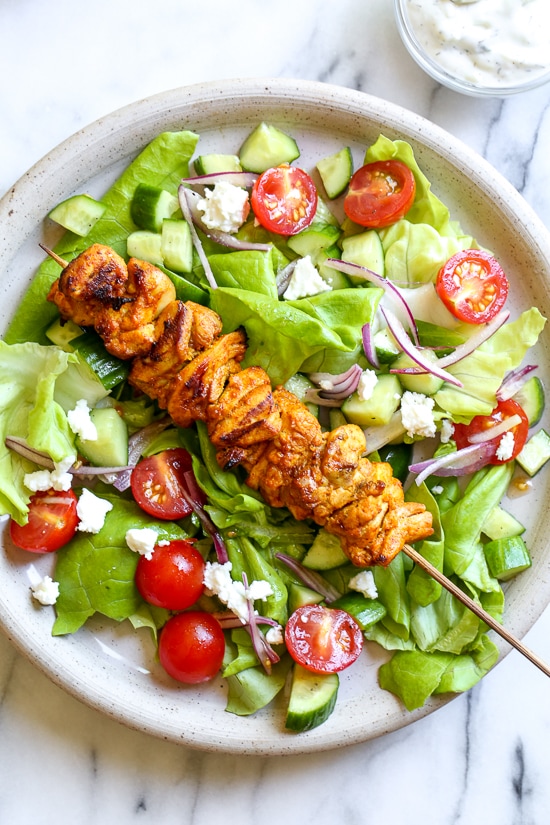 This Mediterranean inspired salad is made with Grilled Chicken Shawarma kebabs served over salad with Feta and Tzatziki.