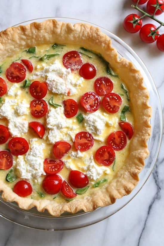This easy vegetarian quiche recipe is made with spinach, ricotta cheese, eggs, tomatoes and basil. Perfect for breakfast, lunch or brunch or serve it with a salad for a light dinner.
