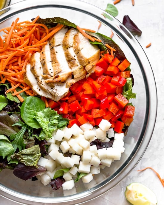 Grilled Chicken Salad with greens and vegetables are tossed in a honey-lime vinaigrette and topped with a delicious peanut sauce.