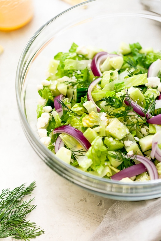 Chopped salad with romaine lettuce, Feta cheese, cucumbers, red onion and dill tossed with a simple red wine vinaigrette. An easy side salad to go with all your Mediterranean dishes.