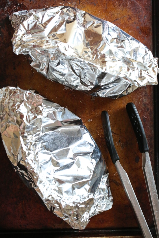 Grilled little neck clams cooked in foil packets with zucchini and tomatoes in a garlic white wine sauce, so fast and easy, perfect to make all summer long!