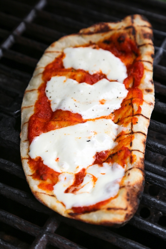 This easy Grilled Pizza is made from scratch with my easy yeast-free Greek yogurt dough, topped with sauce, mozzarella cheese and your choice of toppings. A great summer outdoor meal that whole family can enjoy!