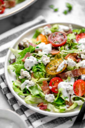 Classic wedge salad meets chopped salad in this easy side salad dish made with lettuce, bacon, blue cheese and chives with a light homemade blue cheese dressing.