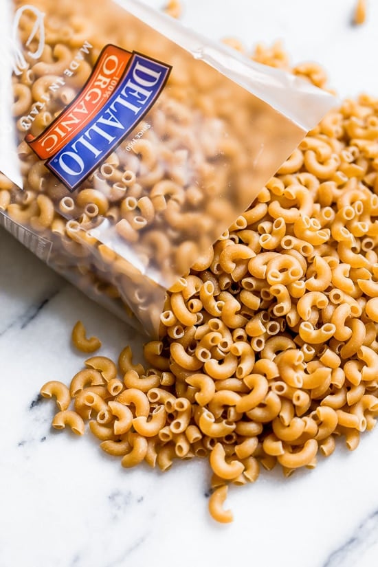 Greek Mac and Cheese, a healthy twist on a comfort food classic made in a creamy cheese sauce with whole wheat pasta, tomatoes, spinach, olives and Feta cheese.