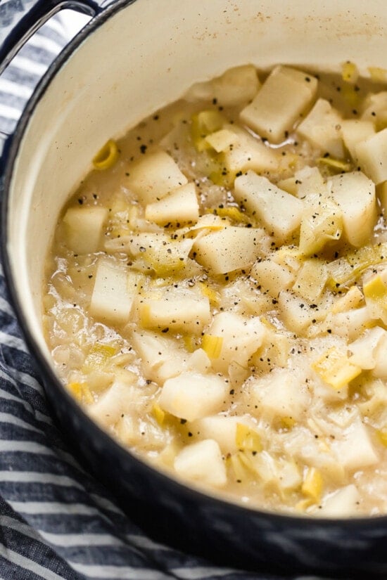 Cozy and comforting, this Potato Leek Soup is an easy soup recipe the whole family will love. It's rich and creamy, without any heavy cream! potatoes and leeks in a pot