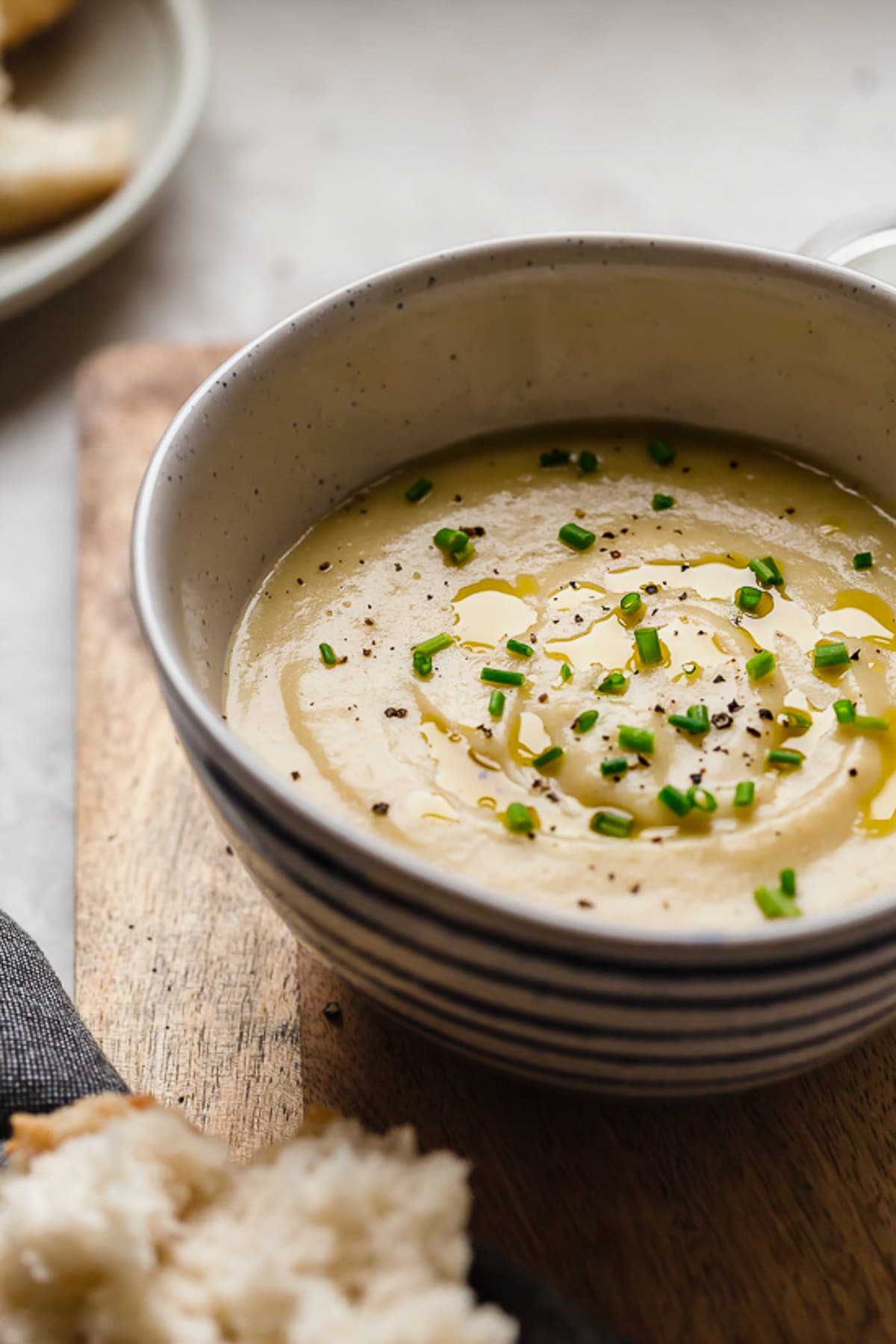 Cozy and comforting, this Potato Leek Soup is an easy soup recipe the whole family will love. It's rich and creamy, without any heavy cream! Bowl of creamy potato leek soup with chives