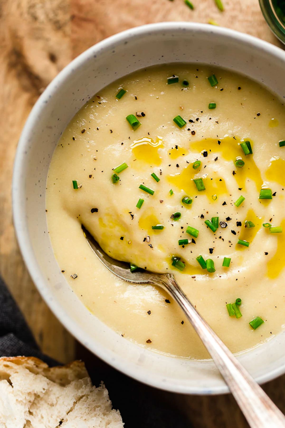 Cozy and comforting, this Potato Leek Soup is an easy soup recipe the whole family will love. It's rich and creamy, without any heavy cream! Overhead view of potato leek soup in bowl with spoon