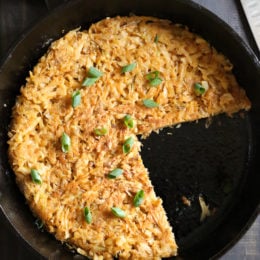 Hash browns in skillet with portions removed