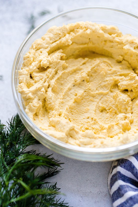 These Instant Pot Deviled Eggs are quick and easy, with a creamy egg yolk filling and a hint of paprika on top. Perfect for potlucks! Deviled egg filling in a bowl