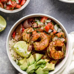 These Shrimp Fajita Bowls are a tasty and easy dinner that your whole family will love! Served over a bed of cilantro-lime rice with peppers and onions, avocado and salsa.
