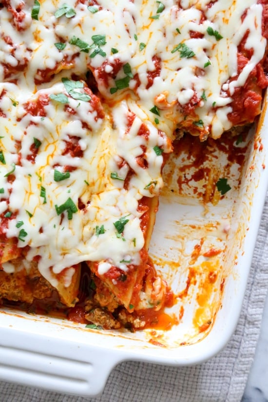 This easy no-boil baked manicotti pasta dish, known as Cannelloni is stuffed with ricotta, parmesan, mozzarella and lean ground beef, then covered in sauce and cheese. Perfect for the holidays, for to bring to a potluck or to enjoy any night of the week!