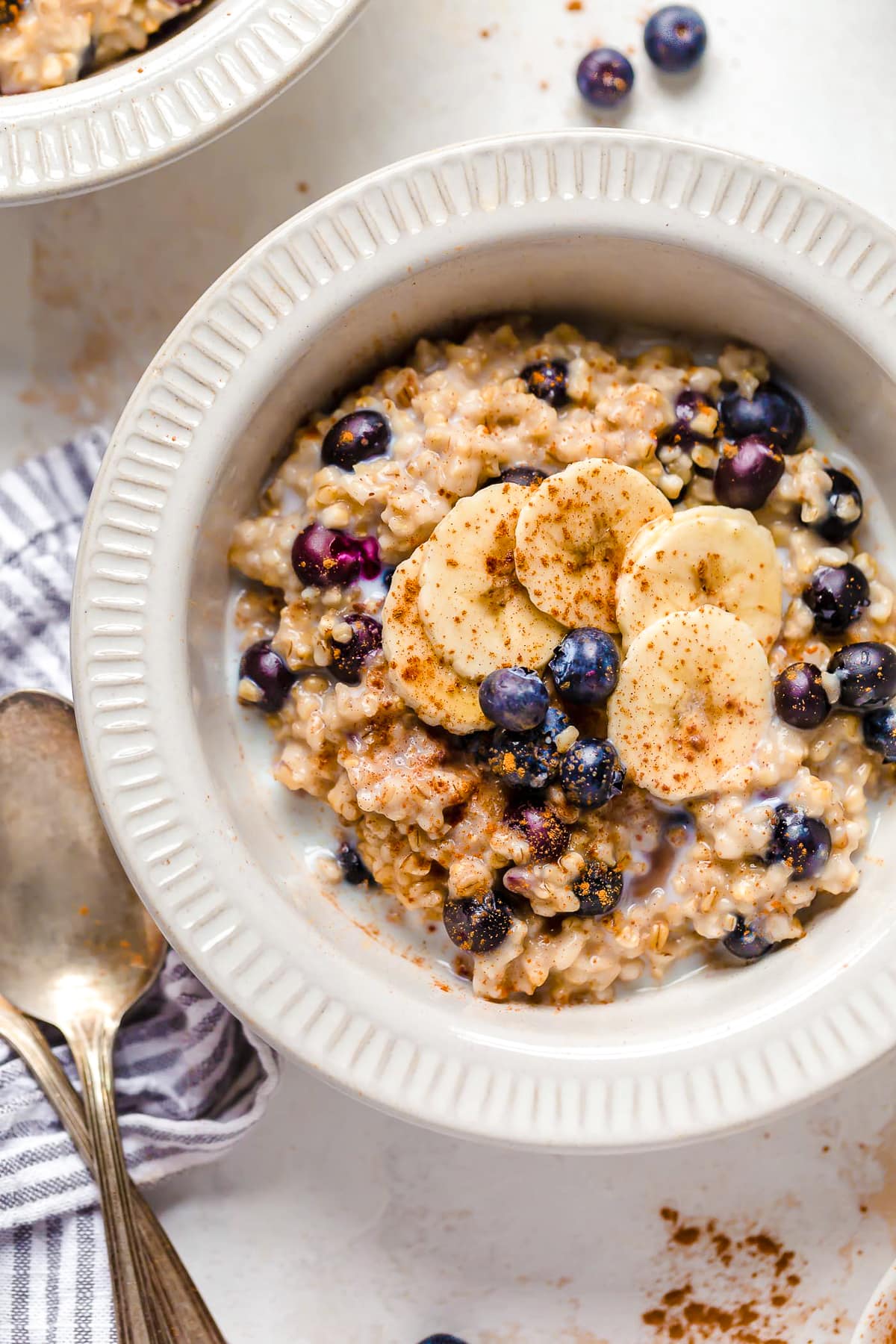 A warm and heart healthy breakfast, making Steel Cut Oats in the Instant Pot is so much faster than making them on the stove! A bowl of steel cut oats with blueberries and bananas