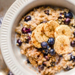 A bowl of steel cut oats topped with blueberries and bananas.