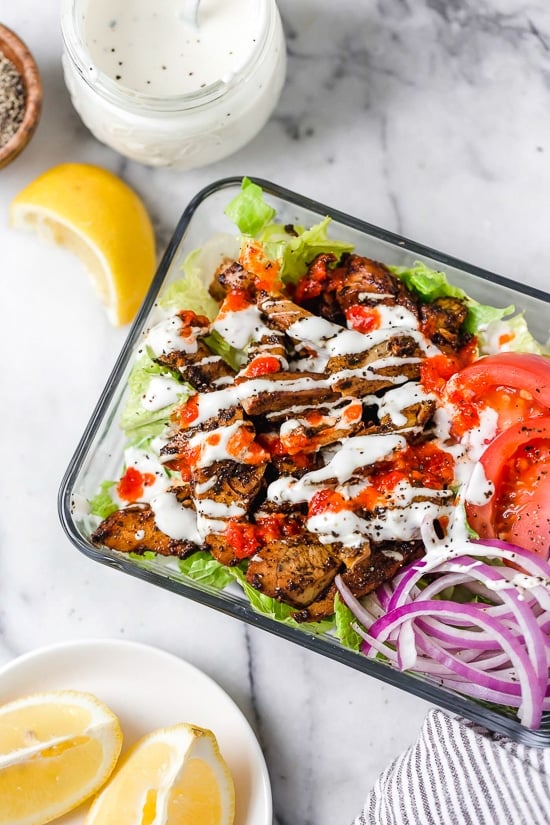 Halal Food Cart inspired chicken served over a big salad of lettuce and tomatoes drizzled with a yummy white yogurt sauce.