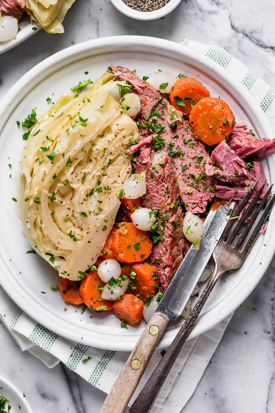 This easy Instant Pot Corned Beef and Cabbage recipe comes out perfectly tender every time! The perfect St. Patrick's Day dinner. A plate of Instant Pot corned beef with cabbage, carrots and onions