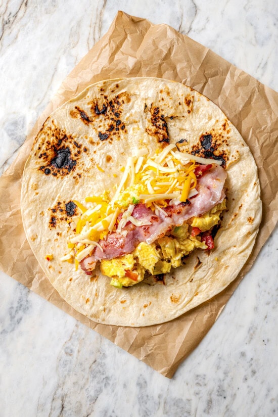 These easy freezer breakfast burritos are a delicious, protein-packed way to start the day with scrambled eggs, veggies, bacon and cheese. Fillings for breakfast burrito on tortilla