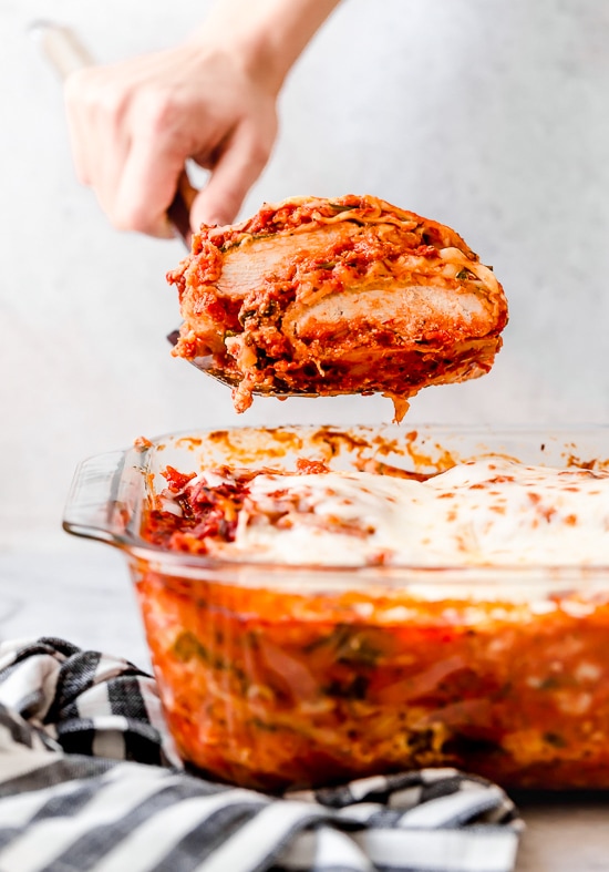 This easy Chicken Parmesan Lasagna is a combination of two classic dishes. It's the perfect family-friendly dish to feed a large crowd! A spatula serving chicken parmesan lasagna