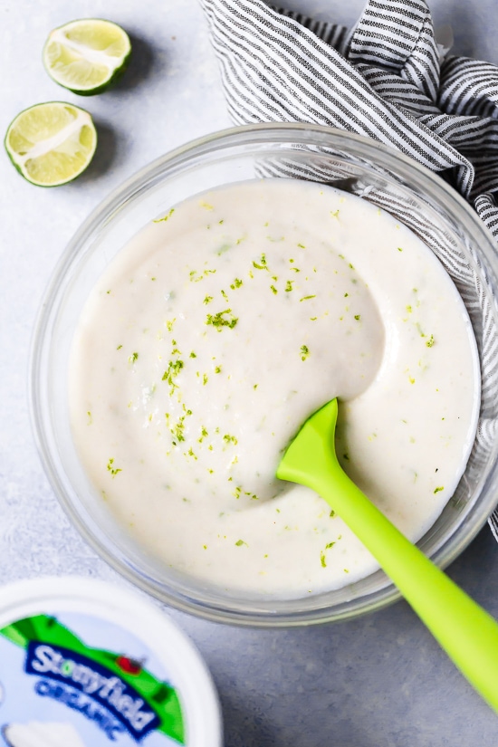 This easy Key Lime Yogurt Pie is a cross between a key lime pie and a key lime cheesecake with a light, creamy filling that is sweet and tart, made with key lime juice, yogurt and cream cheese in a graham cracker crust.