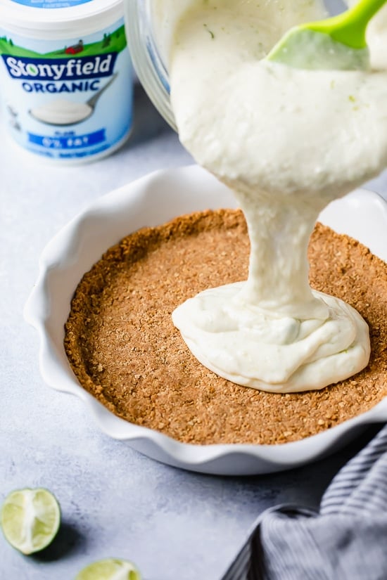 This easy Key Lime Yogurt Pie is a cross between a key lime pie and a key lime cheesecake with a light, creamy filling that is sweet and tart, made with key lime juice, yogurt and cream cheese in a graham cracker crust.