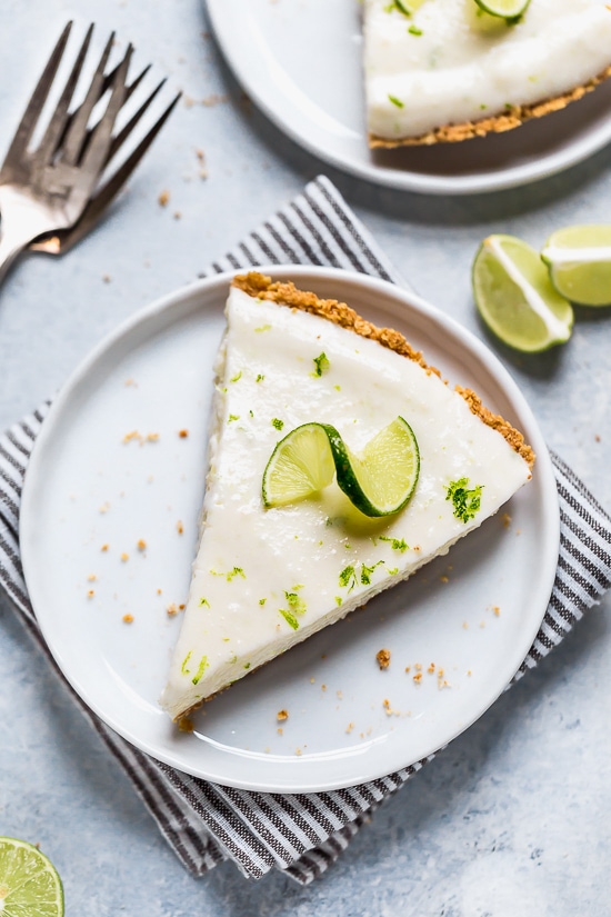 This easy Key Lime Yogurt Pie is a cross between a key lime pie and a key lime cheesecake with a light, creamy filling that is sweet and tart, made with key lime juice, yogurt and cream cheese in a graham cracker crust.