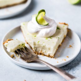 This easy Key Lime Yogurt Pie is a cross between a key lime pie and a key lime cheesecake with a light, creamy filling that is sweet and tart, made with key lime juice, yogurt and cream cheese in a graham cracker crust.