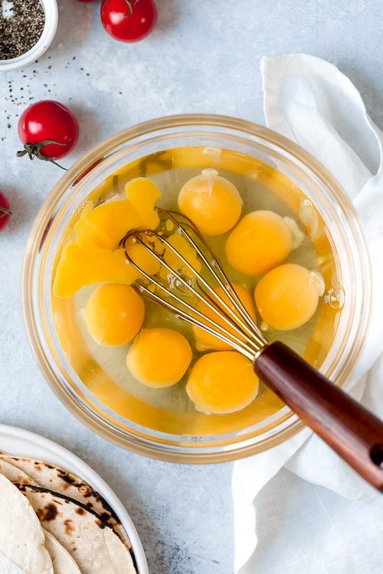 Migas are a classic Tex Mex breakfast recipe, but you can enjoy them anytime of day! Eggs, tortillas, cheese and veggies make them satisfying. Whisking eggs for migas