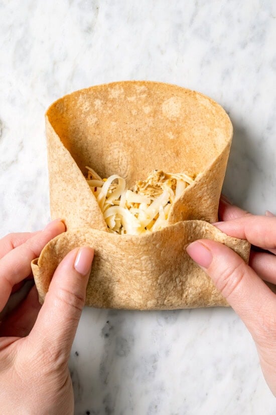 Crispy air fryer chicken chimichangas are an easy and healthier twist on the classic! Filled with cheese, green chiles, and seasoned chicken. Folding chimichanga