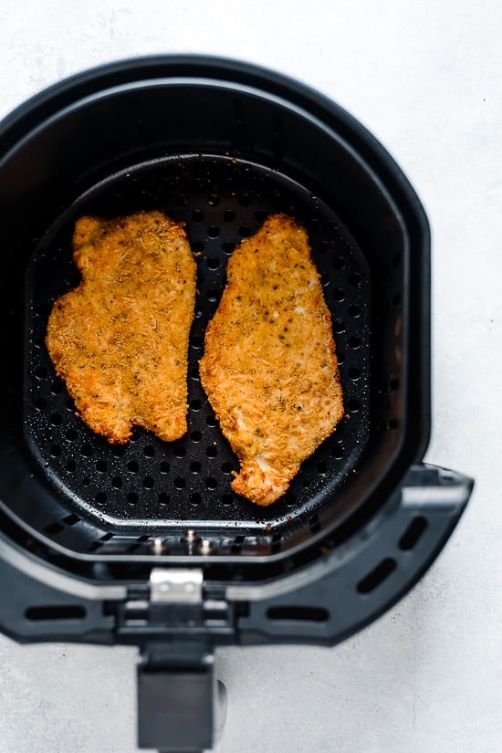 Air Fryer Chicken Cutlets with Arugula and lemon wedges is one of my favorite dinners!