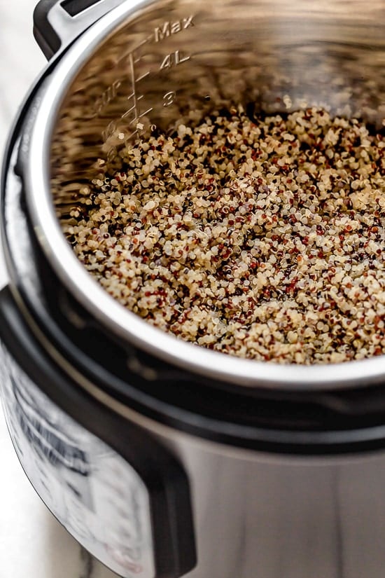Learn how to cook perfect, fluffy Instant Pot quinoa! This hands-free method makes tender quinoa that's great in salads, bowls, and more. Cooked quinoa inside the Instant Pot.
