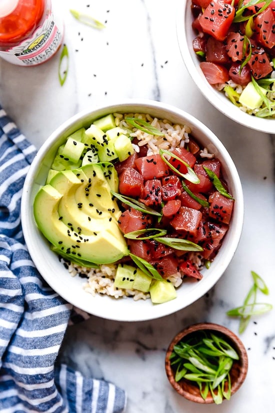Spicy Tuna Poke Bowls made with chunks of fresh tuna, avocado, cucumbers, spicy mayo, scallions cut on the bias served on a bed of steamed rice.
