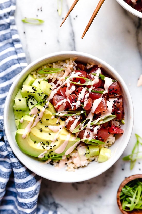Poke Bowls made with chunks of fresh tuna, avocado, cucumbers, spicy mayo, scallions cut on the bias served on a bed of steamed rice.