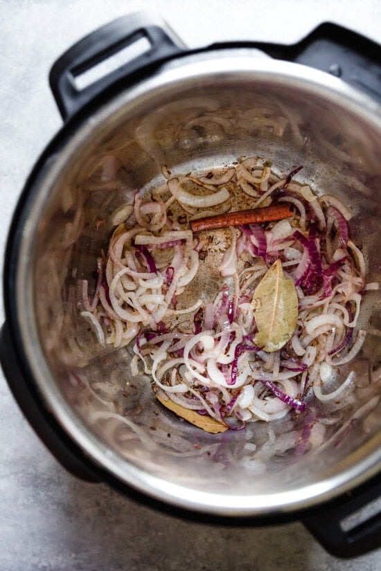 Instant Pot Chicken Pulao comes together in just 30 minutes, with basmati rice, chicken breasts, and a few aromatics and spices. Sliced onion and spices in an Instant Pot