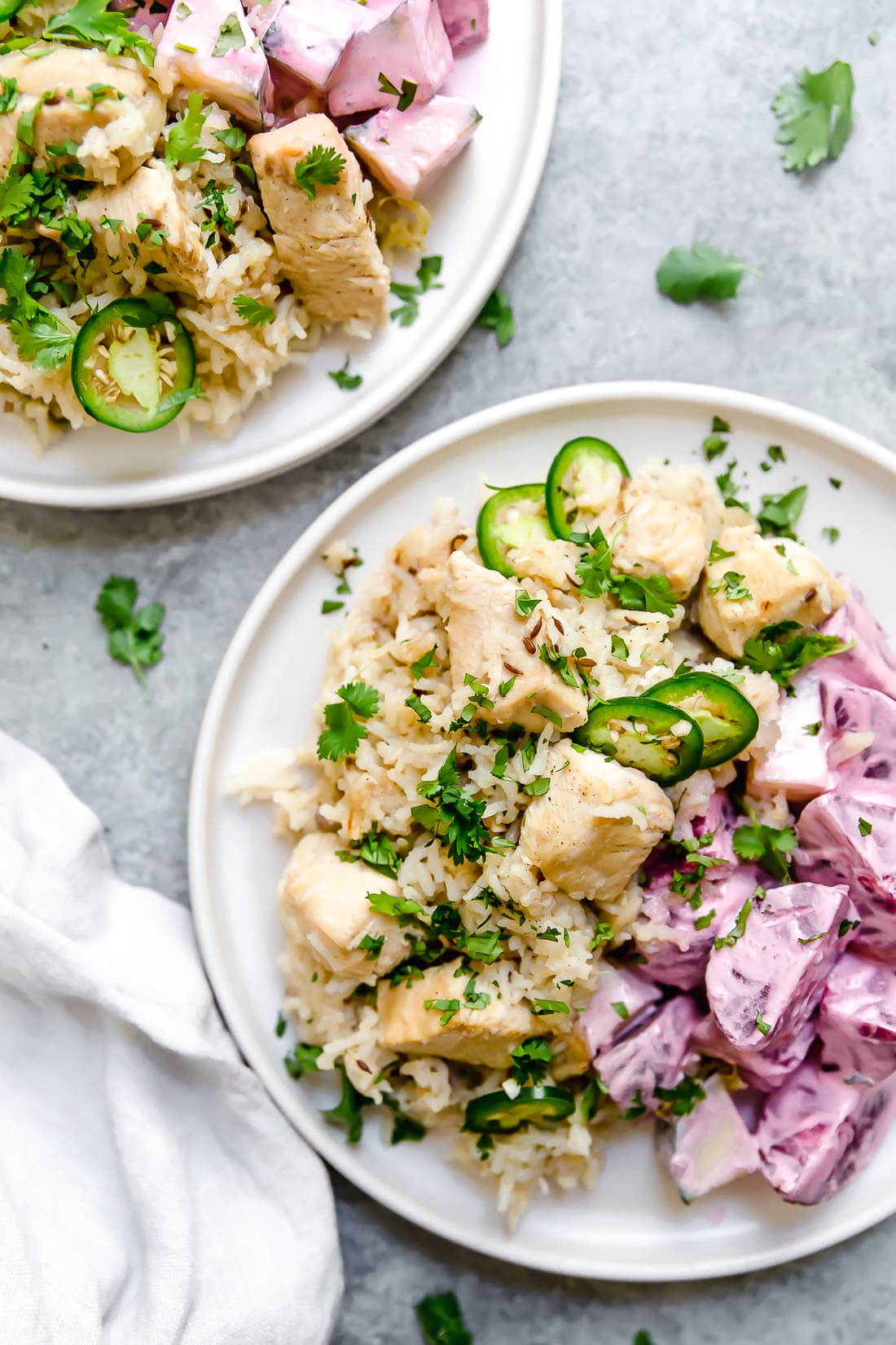 Instant Pot Chicken Pulao comes together in just 30 minutes, with basmati rice, chicken breasts, and a few aromatics and spices. Overhead view of two plates of chicken pulao