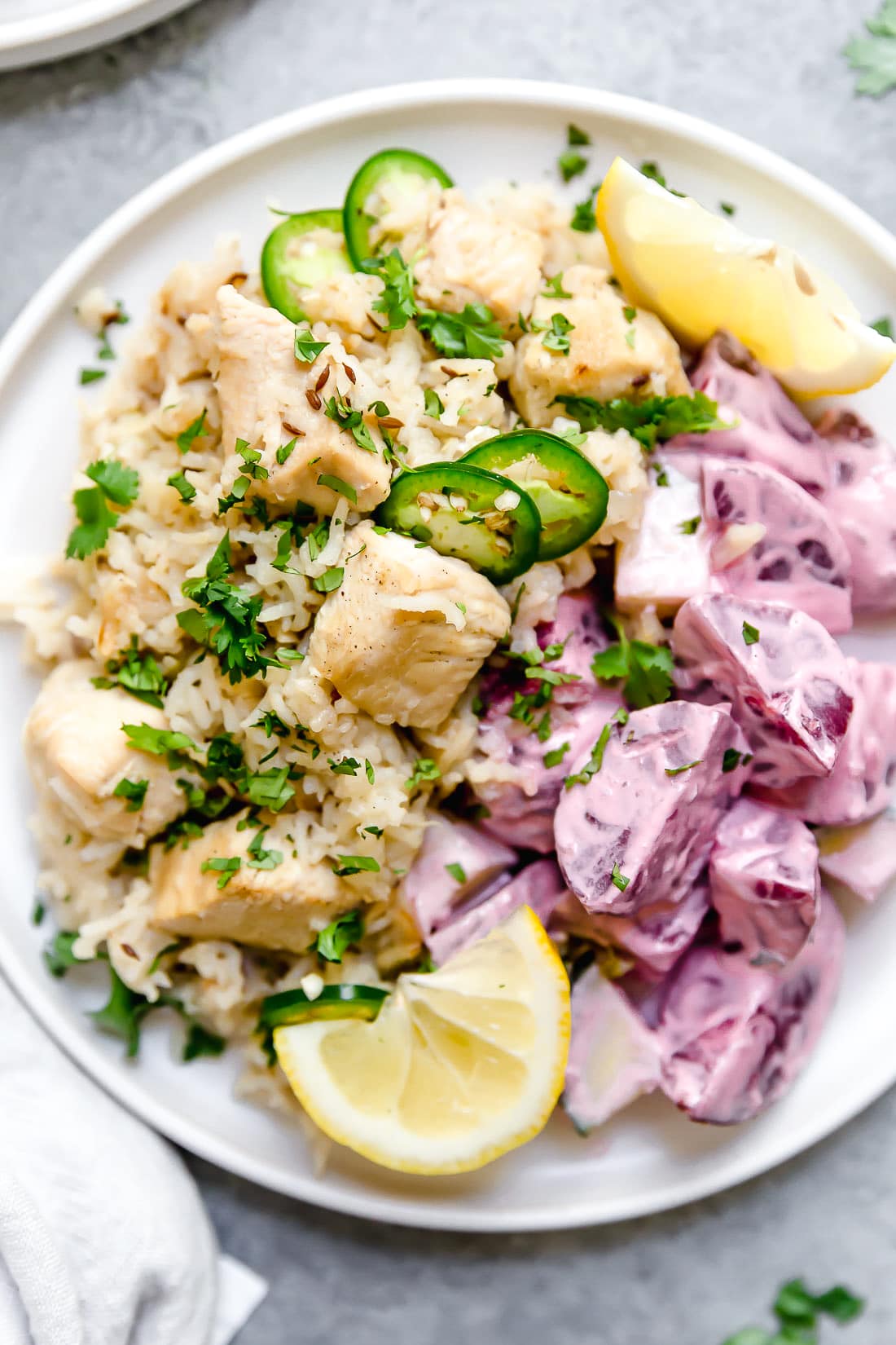 Instant Pot Chicken Pulao comes together in just 30 minutes, with basmati rice, chicken breasts, and a few aromatics and spices. A plate of chicken pulao topped with sliced chiles and lemon wedges