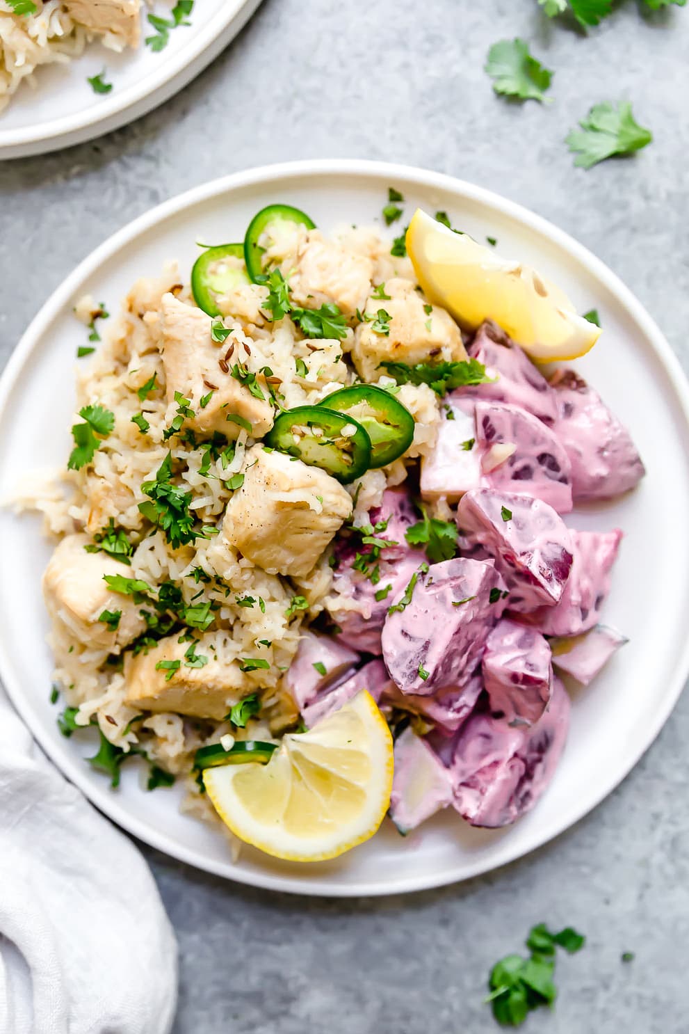 Instant Pot Chicken Pulao comes together in just 30 minutes, with basmati rice, chicken breasts, and a few aromatics and spices. A plate of Indian pulao with lemon wedges